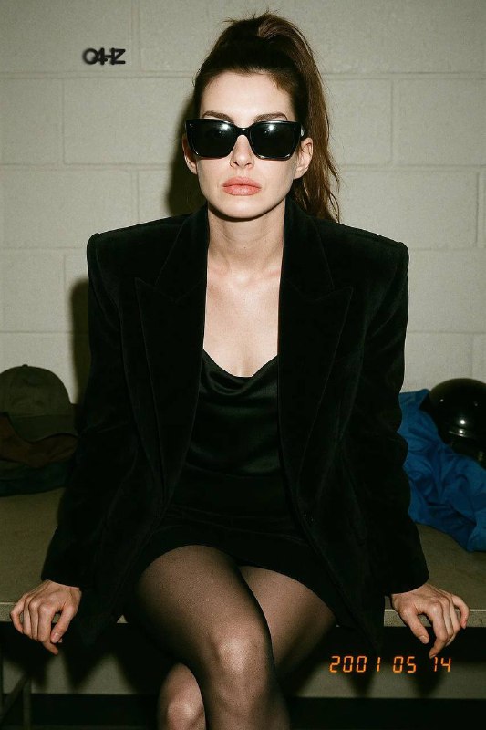 画面采用中景近乎半身的构图，镜头与人物几乎平视，但透视感强烈，但因为主体微微前倾，视觉上产生一种略带俯视感的压缩效果，让观者与模特之间的距离显得亲密而直接